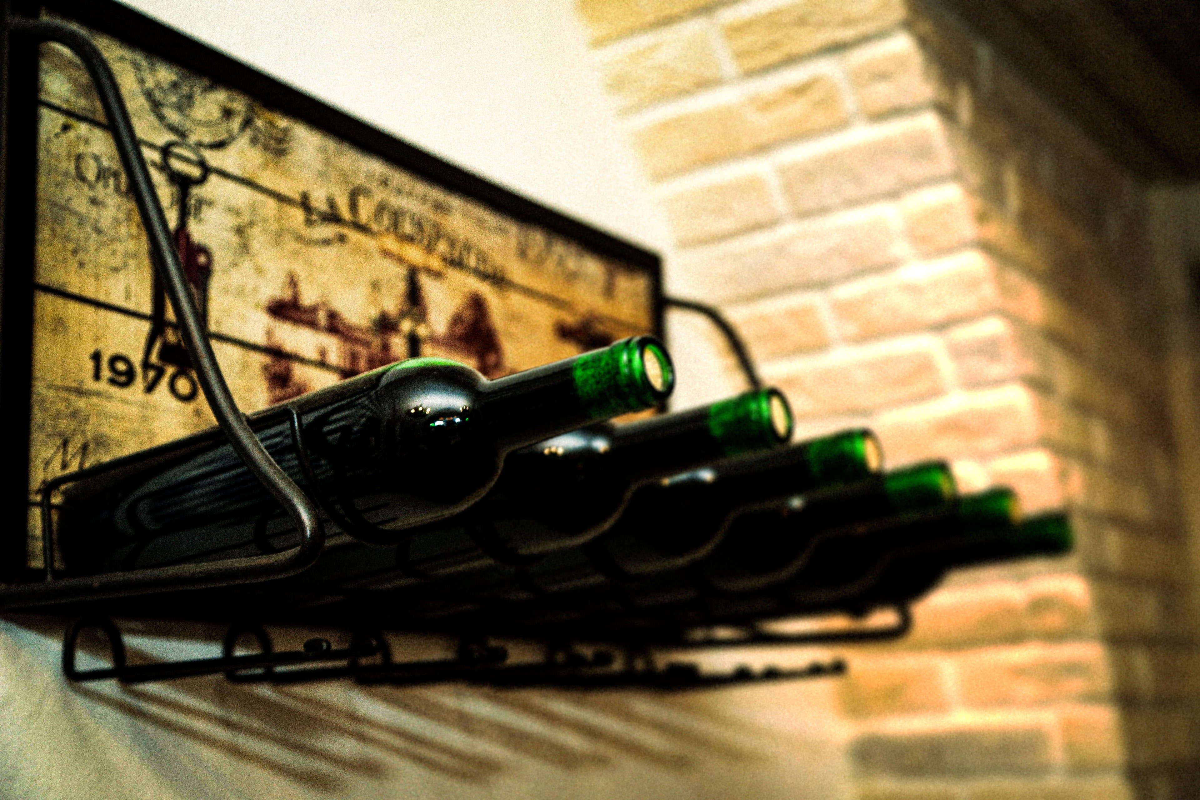 Wine bottles on a rack against a brick wall
